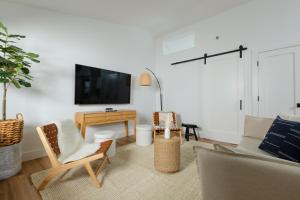 a living room with a couch and chairs and a tv at DUNE Fairfield Beach in Fairfield