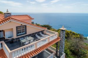 uma casa com uma varanda com vista para o oceano em CASA POR DO SOL na Calheta