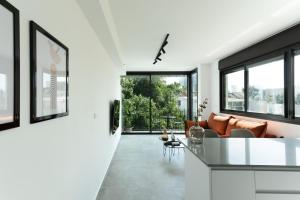 a kitchen and living room with white walls and windows at Zeev Jabotinsky Residence - With Mamad in Tel Aviv