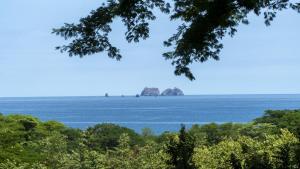 uma vista para o oceano com duas rochas à distância em Bougainvillea 1101 Luxury Apartment - Reserva Conchal em Brasilito