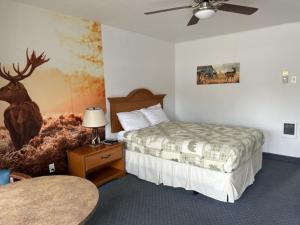 ein Hotelzimmer mit einem Bett und einem Hirsch-Wandbild in der Unterkunft Myrtle Lane Inn in Coquille