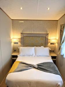 a large bed in a room with two night stands at Tattershall Lakes - Merlin Point in Tattershall