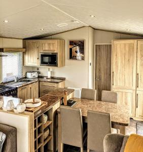a kitchen with wooden cabinets and a counter top at Tattershall Lakes - Merlin Point in Tattershall