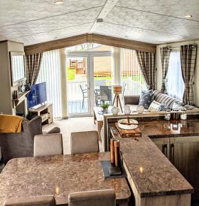 eine Küche und ein Wohnzimmer mit einem Sofa und einem Tisch in der Unterkunft Tattershall Lakes - Merlin Point in Tattershall