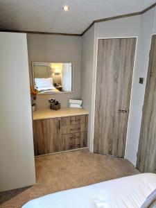 a bedroom with a bed and a mirror at Tattershall Lakes - Merlin Point in Tattershall