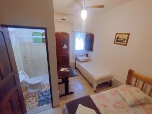 a bedroom with a bathroom with a shower and a bed at Pousada Taquinha Paraty in Paraty