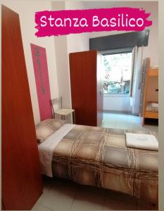 ein Schlafzimmer mit einem Bett mit einem Schild, das Strophe Basilia liest in der Unterkunft Perla del Levante Hostel in Framura