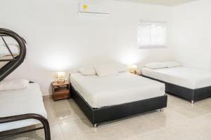 2 łóżka w pokoju z białymi ścianami w obiekcie Finca de Nosotros w mieście Bonda