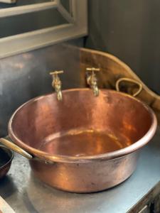 a copper bowl sitting on top of a counter at The Walled Garden at Cheshire Boutique Bathhouse in Nantwich