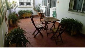un patio con mesa, sillas y plantas en Buenos Aires apartamento, en Guadix