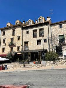 a large brick building on the side of a street at Apartamentos Hoz del Huécar in Cuenca