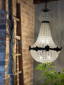 um lustre pendurado numa parede de tijolos em The Walled Garden at Cheshire Boutique Bathhouse em Nantwich