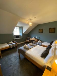 a bedroom with two beds and a table and a window at Ambleside Central in Ambleside