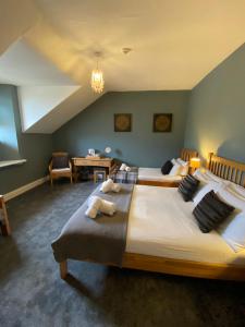 a bedroom with two beds and a desk in it at Ambleside Central in Ambleside