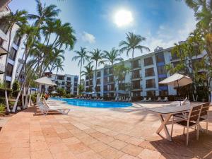 a resort with a pool and chairs and palm trees at Puerto de Luna Pet Friendly and Family Suites in Puerto Vallarta