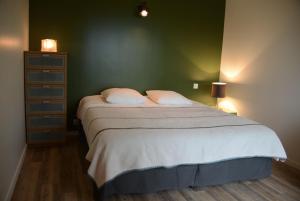 a bedroom with a large bed with a green wall at Villa 1 in Saint-Jacut-de-la-Mer