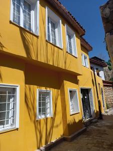 a yellow building with white windows and a door at TAG Pansiyon in Antalya