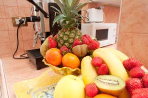 a bowl of fruit on a counter with a pineapple at B&B Babri Simim Taj in Rome +18 photos