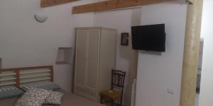 a bedroom with a bed and a tv on a wall at Cummersa dell'alba in Locorotondo