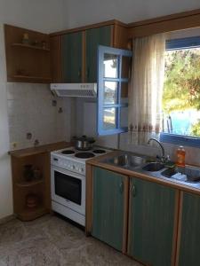 a kitchen with a stove and a sink and a window at Bella Vista in Sikinos