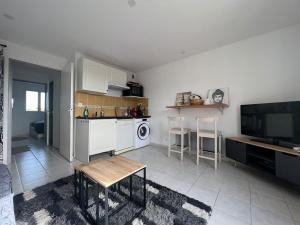 a living room with a kitchen with a table and a tv at Appartement Paradou vue magnifique in Paradou