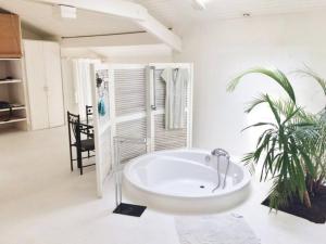 a large white bathroom with a tub and a palm tree at BRUYERES - Capbreton, belle villa spacieuse entre ville et plages au calme in Capbreton