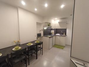 a kitchen with a table and chairs in a room at Pelso Holiday Apartments Jasmin in Siófok