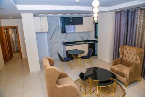a kitchen and a living room with chairs and a table at Geneva Hotel in Douala