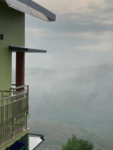 a balcony of a building with a view of the ocean at Vaga Mist Resort Vagamon in Idukki