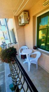 プリモルスコにあるGuest House Nataliのバルコニー(椅子2脚、テーブル付)、窓が備わります。