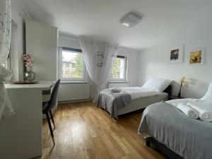 a bedroom with two beds and a desk and a desk at Domek Przy Termach in Jelenia Góra