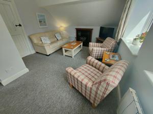 a living room with two chairs and a couch at Pant Glas Barn in Llanbrynmair