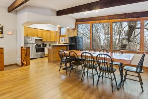 a kitchen and dining room with a wooden table and chairs at 3 Level Ski Chalet 7BR w Deck, Sauna & Ping-Pong! in Blue Mountains