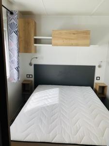 um quarto com uma cama branca num quarto em Mobil home 6/8 personnes camping 4*Frejus em Fréjus