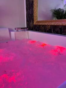 una habitación con una piscina de sangre rosa en una habitación en La balnéo du Couvent, en Dijon