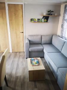 ein Wohnzimmer mit einem Sofa und einem Couchtisch in der Unterkunft Mobil home 6/8 personnes camping 4*Frejus in Fréjus