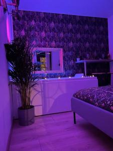 a purple room with a bed and a mirror at La balnéo du Couvent in Dijon