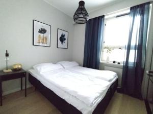 a bedroom with a white bed and a window at Galle BnB boheemi kaksio in Pori
