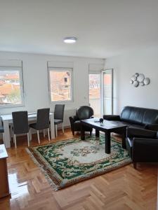 a living room with a couch and a table and chairs at Nikolici - Free Parking in Vranje