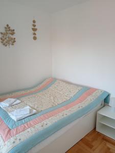 a bed in a room with a white wall at Nikolici - Free Parking in Vranje