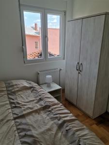 a bedroom with a bed and a dresser and a window at Nikolici - Free Parking in Vranje