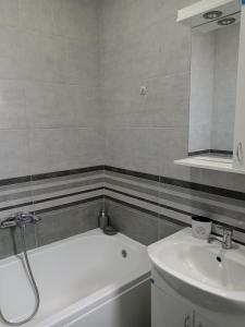 a bathroom with a white tub and a sink at Nikolici - Free Parking in Vranje