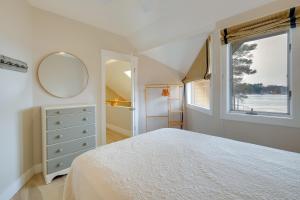 a bedroom with a bed and a mirror and a window at Elk Rapids Condo with Balcony Overlooking Elk Lake! in Elk Rapids