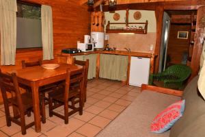 uma cozinha com uma mesa e cadeiras num camarote em ABEDULES CABAÑAS PEHUENIA em Villa Pehuenia