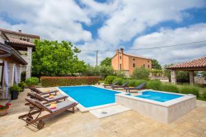 a swimming pool in a backyard with chaise lounges at Villa Medvidići in Rajki