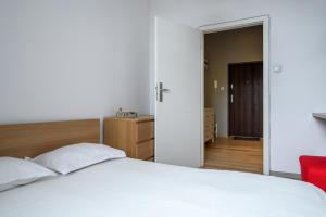 ウッチにあるRent-Apart City Center Kopernikaのベッドルーム(白いベッド1台、赤い椅子付)