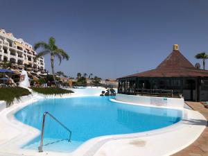 una gran piscina en un complejo con un edificio en Rocas del Mar with heated Pool and double Terrace, en Costa del Silencio