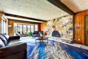 a living room with a couch and a stone fireplace at Spacious Buffalo Brick Home w/ Backyard! in Buffalo