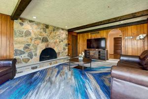 a living room with a stone fireplace and a tv at Spacious Buffalo Brick Home w/ Backyard! in Buffalo