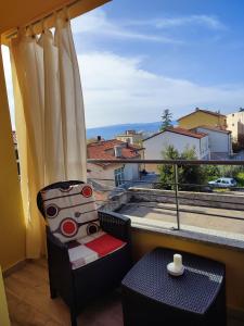 a balcony with a chair and a table and a window at B&B Fradama' Holiday in Dorgali